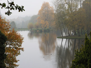 Fototapeta premium Mist and Autumn colour in the reflected in lake