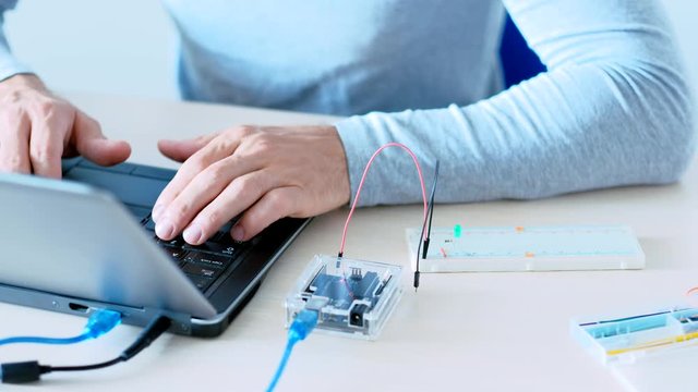 Engineering science. Experimental work. IT programmer creating project with microcontroller.