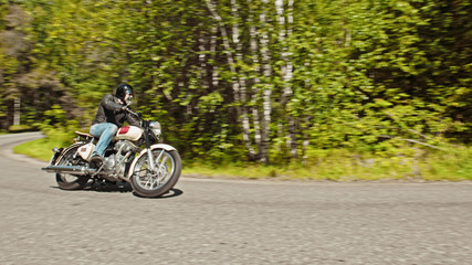 Obraz premium Rowerzysta skręca w drogę w lesie