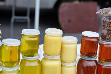 Different varieties of sweet golden and white honey at the farmers market. Natural honey in various jars.Vitamin healthy food