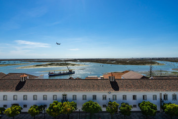 Fototapeta premium Panoramic view from the tower bell of Faro Cathedral (Church of Santa Maria) with a plane landing at Faro airport, Algarve, Portugal