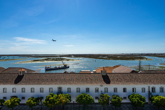 Panoramic view from the tower bell of Faro Cathedral (Church of Santa Maria) with a plane landing at Faro airport, Algarve, Portugal