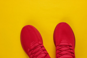 Stylish men's red sports shoes for running on a yellow background. Top view