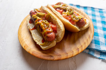 Hot dog with jalapeno pepper and tomato on white background