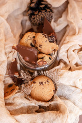 Fototapeta premium Shortbread chocolate cookies and a glass of milk on a brown background. Milk chocolate with nuts and cookies.