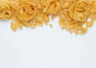 Different types of raw italian pasta on white background. Top view. Copy space