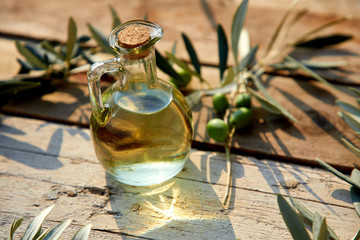 olive oil and green olive on the wooden background