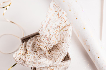 Gift wrapping. Festive wrap paper for Christmas, New Years Eve celebration. White, golden, silver festive colors. Holiday season. Handmade gift box packing.