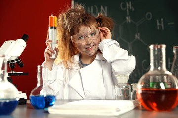 Child doing chemical research in laboratory. Dangerous experiment