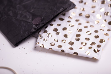 Gift wrapping. Festive wrap paper for Christmas, New Years Eve celebration. White, golden, silver festive colors. Holiday season. Handmade gift box packing.