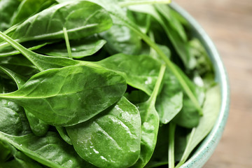 Fresh green healthy spinach in ceramic bowl, closeup