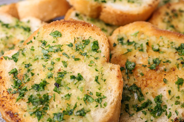 Slices of toasted bread with garlic and herbs as background, closeup