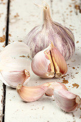 Garlic bulbs and cloves on peeling paint plank table