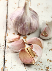 Garlic bulbs and cloves on peeling paint plank table