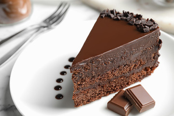 Delicious fresh chocolate cake served on white table, closeup