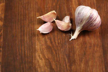 Garlic bulbs and cloves on wooden table, copy space.