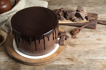 Freshly made delicious chocolate cake on wooden table. Space for text