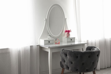Elegant white dressing table and armchair in light room