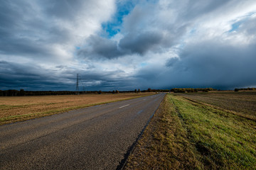 Fototapeta premium storm clouds over asphalt road in perspective