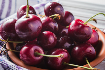 Cherry berry on the table, water, drops of water. Fresh fruit is useful on a wooden table.