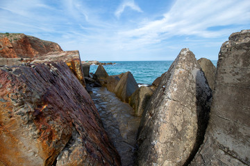 Seascape. A stone path between huge concrete blocks of Bolata Beach. Northern Black Sea Coast, Bulgaria.