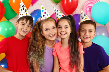 Happy children near bright balloons at birthday party indoors