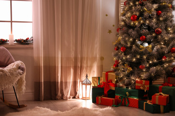Stylish room interior with beautiful Christmas tree and gift boxes