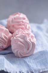 Homemade pink marshmallow on the blue linen napkin, close-up