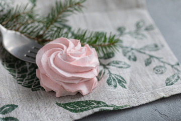 Homemade pink marshmallow on fork with Christmas fir-tree branches
