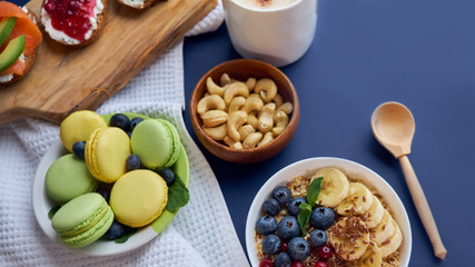 breakfast top view black background. oatmeal with berries, toasts on a wooden tray, nuts, coffee