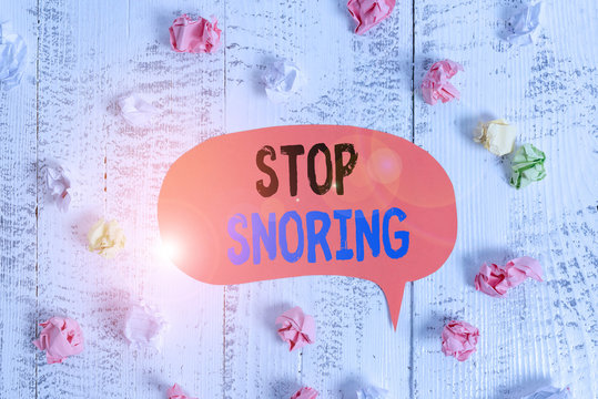 Conceptual hand writing showing Stop Snoring. Concept meaning noisy breathing during sleep due to vibrating airway tissue Colored speech bubble paper balls wooden rustic vintage background