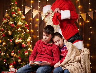 The children waited a long time for Santa, now they fell asleep and Santa quietly goes to the Christmas tree to give presents - Merry Christmas and Happy Holidays!