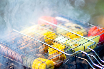 Closeup grilled vegetables on the grill. Corn, mushroom and pepper close-up are cooked on a...