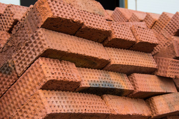 New red clay bricks stacked. Material for construction. Brick building.