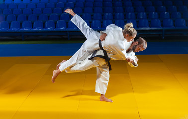 Martial arts. Sparing Portners. Sport man and woman in white kimono train judo throws and captures...