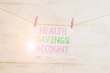 Writing note showing Health Savings Account. Business concept for users with High Deductible Health Insurance Policy Clothesline clothespin rectangle shaped paper reminder white wood desk