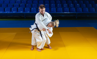 Martial arts. Sparing Portners. Sport man and woman in white kimono train judo throws and captures...