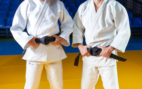 Two masters of sports in judo in a white kimano with a black belt. Crop photo