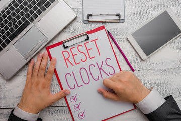Writing note showing Reset Clocks. Business concept for To revisit return to or recreate a time or...