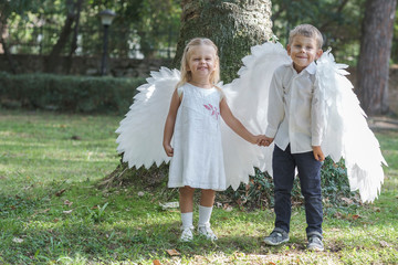 Children dressed as angels walk in the park
