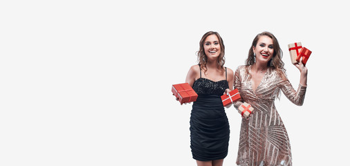 Fototapeta premium Two young girls with red presents in hands isolated on white background.