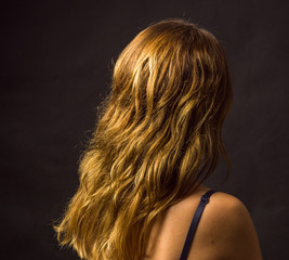 Portrait of young woman, no make up, low key, brown dark hair, no retouch making expressions