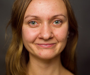 Portrait of young woman, no make up, low key, brown dark hair, no retouch making expressions