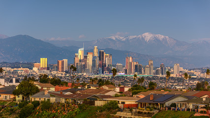 Obraz premium Downtown Los Angeles skyline with snow capped mountains behind at sunset