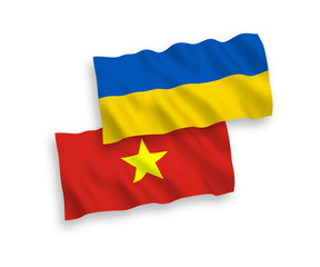 National vector fabric wave flags of Vietnam and Ukraine isolated on white background. 1 to 2 proportion.
