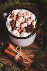Metal mug of hot chocolate with marshmallows on wooden background. Сinnamon and star anise.