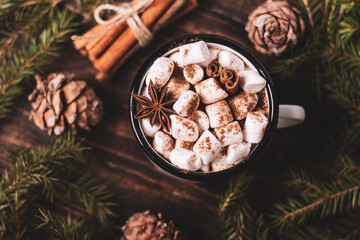 Metal mug of hot chocolate with marshmallows on wooden background. Сinnamon and star anise.