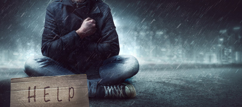 Obdachloser auf einer Stra&szlig;e im Regen