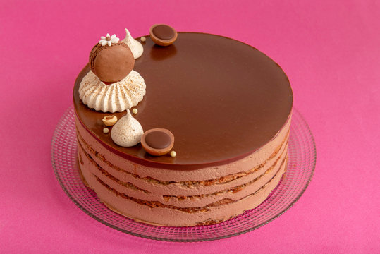 layered cocoa cake on pink background with toffifee and meringue,  with space for text
