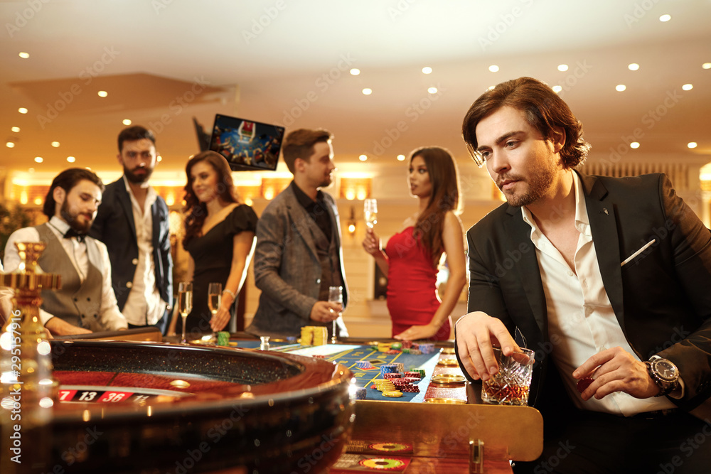 Wall mural A man in a suit against the background of a roulette game in a casino.